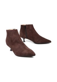 Brązowe zamszowe botki za kostkę z szpiczastym noskiem i zapięciem na zamek z boku. Posiadają mały obcas typu kitten heel oraz gładką fakturę.