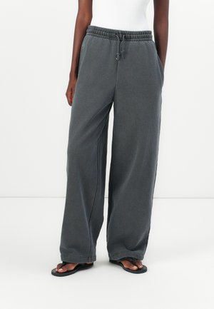 Wijd-uitlopende, donkergrijze sweatpants gemaakt van zachte stof, met een elastische tailleband met een trekkoord en zijzakken. Casual ontwerp.