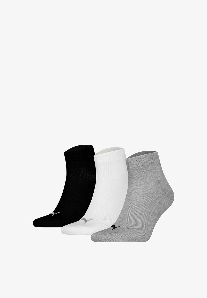 Tres pares de calcetines de tobillo en negro, blanco y gris. Hechos de tela suave con puños acanalados y un patrón de logotipo en las suelas.