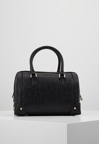 Zwarte handtas met gegraveerd "GUESS" logo, ronde handvatten, zilverkleurige hardware accenten en contrasterende hoekdetails. Gladde textuur.