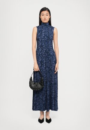 Navy blue floral maxi dress with a high neckline and sleeveless design, accompanied by a small black handbag with silver studs.
