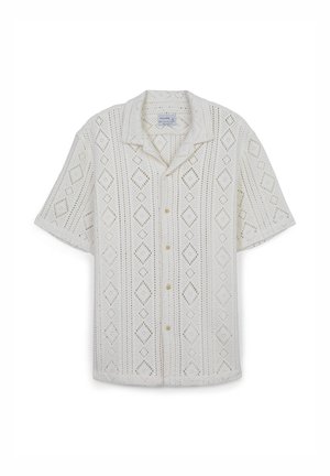 Camicia bianca a maniche corte con un motivo a diamante taglio gemma, realizzata in tessuto leggero e testurizzato; presenta una chiusura con bottoni e un colletto.