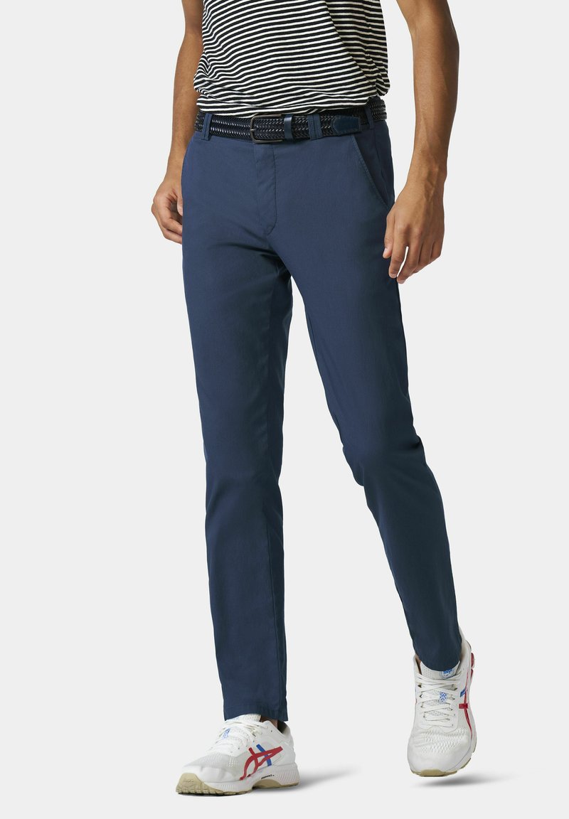 Marineblauwe chino's met een slim fit, gemaakt van lichtgewicht stof. Gecombineerd met een gestreept overhemd en witte sneakers met multikleuren accenten.