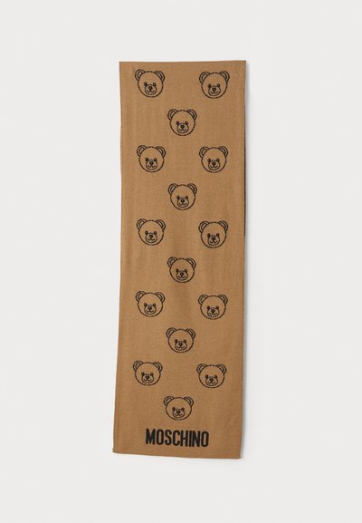 Ruskea huivi, jossa on toistuvia mustia karhun kasvojen kuvastoja ja "MOSCHINO"-teksti mustana pohjassa. Pehmeä rakenne ja suorakulmainen muoto.