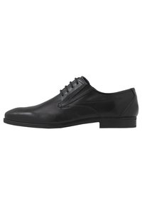 Scarpa da uomo nera con stringhe realizzata in pelle liscia, dotata di punta arrotondata, dettagli di cucitura sottili e un pannello testurizzato sul lato.