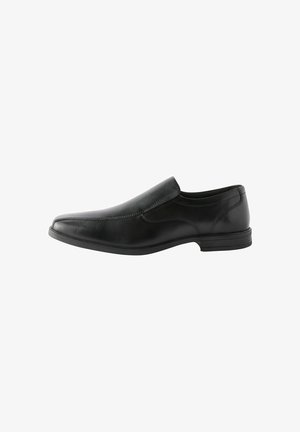Zapato negro de piel sin cordones con un diseño elegante, punta puntiaguda y un detalle de costura sutil a lo largo de los lados. Suela de goma para mayor adherencia.