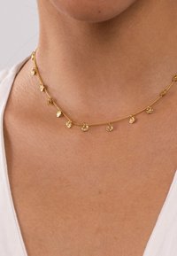 Goldene Halskette mit kleinen, runden Anhängern, die gleichmäßig entlang der Länge verteilt sind. Filigranes, gliedriges Design mit einem sanften Glanz.