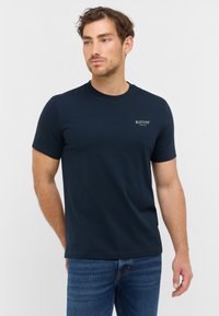 T-shirt en coton navy avec un col rond, des manches courtes et un petit logo blanc "MUSTANG" sur la poitrine. Texture douce, coupe régulière.