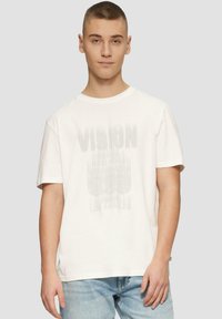 Witte katoenen T-shirt met korte mouwen, voorzien van een vervaagde grafische print met het woord "VISION" en stadsnamen in grijs.