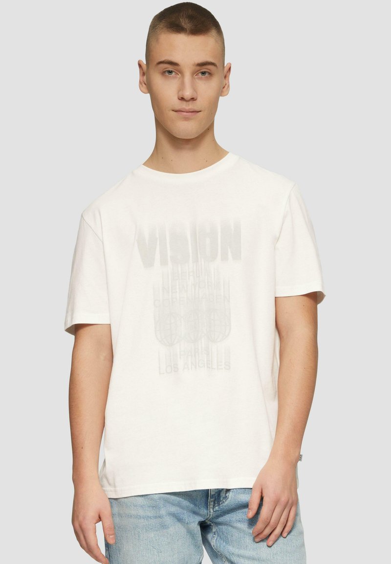 Witte katoenen T-shirt met korte mouwen, voorzien van een vervaagde grafische print met het woord "VISION" en stadsnamen in grijs.