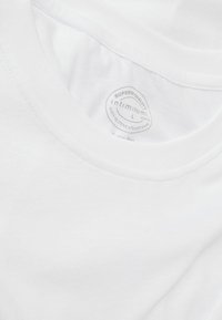T-shirt en coton blanc avec un col rond. Présente une texture lisse et une étiquette à l'intérieur indiquant "intimissimi, qualité supérieure, L."
