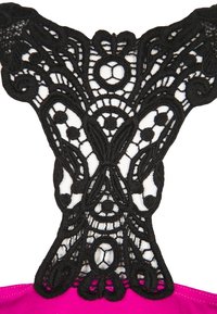 Design sul retro in pizzo nero con motivi e dettagli intricati, abbinato a una base in tessuto rosa vivace. Struttura testurizzata ed elegante.