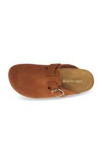 Sabot en daim marron avec une sangle à boucle ajustable et une semelle intérieure rembourrée, marqué "Les Tropeziennes" à l'intérieur.