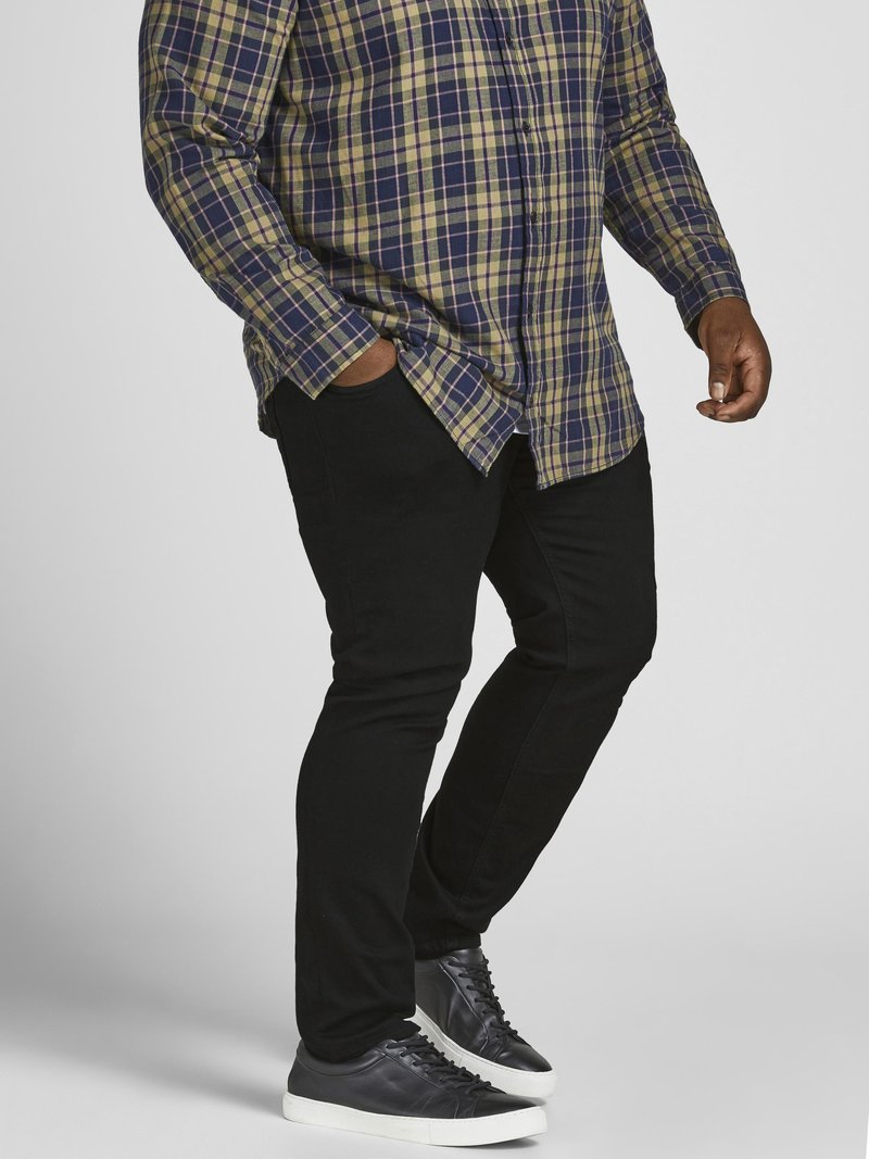Men's plaid button-up shirt in blue, green, and yellow; paired with black pants and black leather sneakers with white soles.