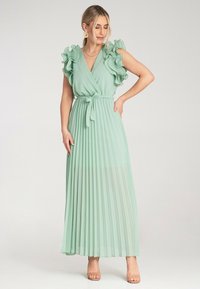 Maxi sukienka w jasnozielonym materiale z plisowanym wzorem, głębokim dekoltem w kształcie litery V oraz falbaniastymi rękawami. Zawiera pasek nawiązujący do talii, umożliwiający dopasowanie.