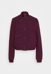 Burgundy bomber jacket with a round neckline, two front pockets, and snap button closure. Soft fabric with ribbed cuffs and hem.
