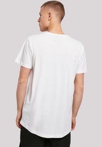 White cotton T-shirt with a relaxed fit, rounded neckline, and short sleeves. The back features a straight hem and minimal design details.