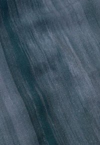Tejido oscuro con una textura suave y un brillo sutil. Presenta un patrón en forma de ola con diferentes tonalidades de azul y verde.