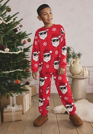 Rotes Pyjama-Set mit Santa-Gesichtern, die Sonnenbrillen tragen, und Schneeflocken auf einem weichen Stoff. Lockerer Sitz mit langen Ärmeln und passenden Hosen.