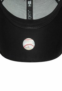 Schwarze Baseballmütze mit einem gebogenen Schirm. Verfügt über ein gesticktes Logo und einen runden MLB-Zertifizierungsaufkleber auf der Innenseite des Schirms.