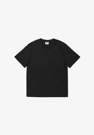 Czarny T-shirt z krótkim rękawem i okrągłym dekoltem z małym, prostokątnym naszywką z logo na środku klatki piersiowej.