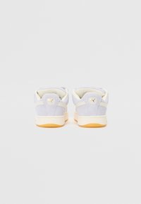 Sapatos de camurça lilás claro com uma entressola creme e sola exterior de borracha goma. Apresenta detalhes em logo dourado e um colarinho acolchoado para maior conforto.