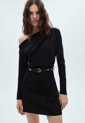 Schwarzes Ein-Schulter-Kleid aus elastischem Stoff, mit langen Ärmeln, figurbetontem Schnitt und einem geschnürten schwarzen Gürtel mit goldenen Beschlägen.
