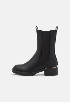 Schwarze Knöchel Boots aus glattem Leder mit elastischen seitlichen Einsätzen, einer abgerundeten Spitze und einem Blockabsatz, der eine dezente goldene Akzentuierung aufweist.
