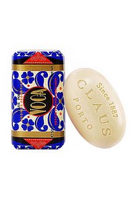 Blaue und weiße, blumengemusterte Seifenverpackung neben einer beigen, ovalen Seife, geprägt mit "CLAUS" und "Seit 1887", mit glatter, cremiger Textur.