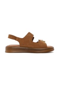 Brown suede sandal with an open toe, cut-out design, and a back strap. Features a textured sole and a decorative metal accent.
