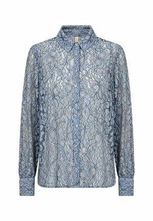 Blusa de encaje en azul claro con patrón floral, con botones en la parte delantera y un cuello clásico. Mangas largas con puños abotonados. Textura transparente.