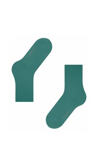 Grüne Knöchelsocken aus weichem Material, mit einer glatten Textur und einem Logo-Akzent in Hellrosa an der Seite.