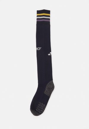 Calcetas azul marino hasta la rodilla con puños de rayas multicolores. Plantilla texturizada con acento gris. Presenta el logo de MCF y la marca Adidas.