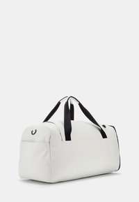 White duffel bag with black handles and accents, made of smooth material. Features a rounded shape and a top zipper closure.