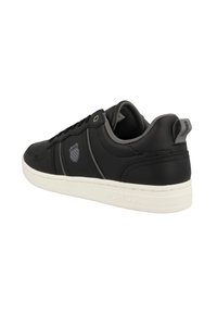 Black synthetic sneaker with white rubber sole, grey accents, lace-up design, and logo detail on the side and heel.