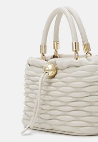 Borsa strutturata in morbida pelle bianca con texture trapuntata. Presenta hardware dorato, manici doppi e una chiusura decorativa con coulisse.