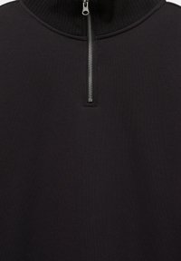 Svart kvartszipsweater med ribbad krage och slät tygstruktur, med en silverfärgad dragkedja i mitten.