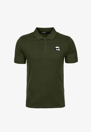 Olivově zelená polo košile vyrobená z bavlny, s třemi knoflíčky a malým vyšitým logem na levé části hrudníku.