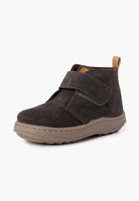 Stivaletti alla caviglia in suede grigio scuro con una fascia in velcro, punta rotonda, suola in gomma marrone chiaro e linguetta sul tallone di un tan a contrasto. Texture morbida in tutto.