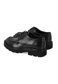 Chaussures en cuir noir avec un bout arrondi et une semelle en caoutchouc épaisse, dotées de lacets et de détails de couture subtils.