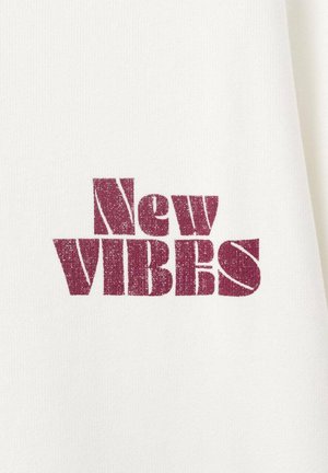 Hvid bomuldsstof med fed, vinrød tekst, der lyder “New VIBES” i en slidt skrifttype. Enkel og klar design.