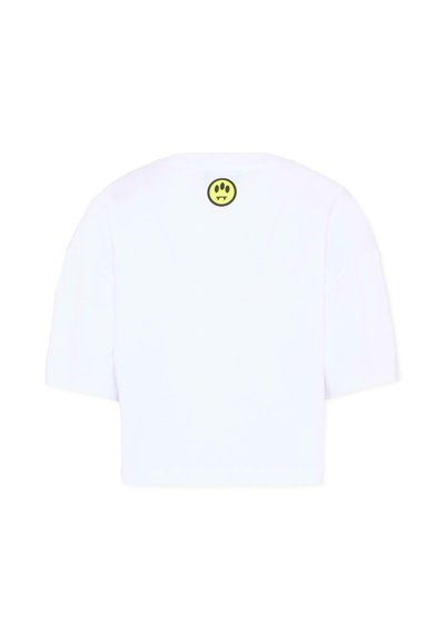 Biały krótki t-shirt z krótkimi rękawami, z małą żółtą emotikoną z trzema czarnymi oczami i kłami na górnej części pleców.