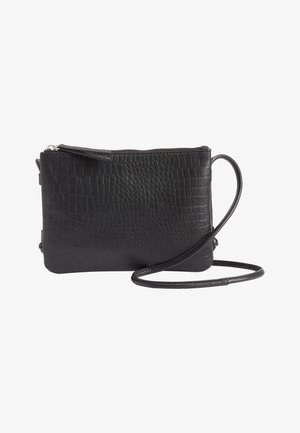 Bolso bandolera negro con patrón texturizado de imitación cocodrilo y cierre de cremallera, con una correa delgada ajustable sobre fondo blanco.