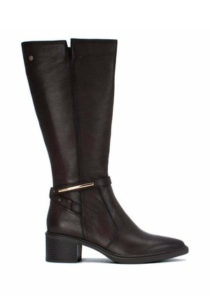 Bota alta de cuero marrón oscuro con tacón bajo de bloque y correa decorativa cerca del tobillo sobre fondo blanco.