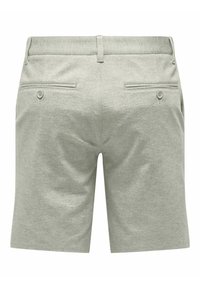 Lichtgrijze shorts van een zacht materiaal met een gladde textuur. Voorzien van twee achterzakken met knopen en een platte tailleband.