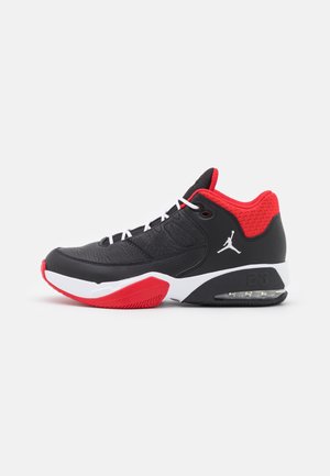 Chaussure de basketball Air Jordan noire et rouge avec des lacets blancs, une semelle blanche, un coussin d’air visible et un logo Jumpman sur le côté.