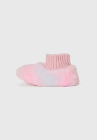 Pantoufle douce et duveteuse rose et blanche avec un poignet en tricot doux, vue de côté sur un fond uni.