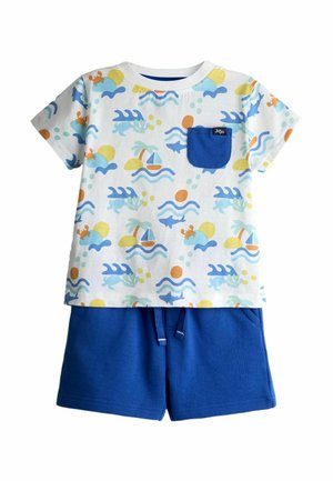 Hvid kortærmet toddler-skjorte med blå ocean-tema prints og en blå lomme, kombineret med ensfarvede blå snøre-shorts.