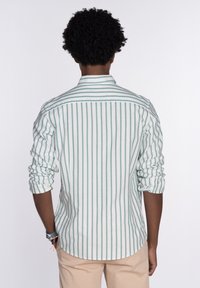 Camisa de manga larga a rayas en blanco y verde, de algodón, con cuello abotonado, mangas enrolladas, dobladillo curvado y sin marcas visibles.