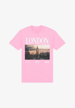 T-shirt di cotone rosa con grafica di Londra che mostra Big Ben, testo contornato "LONDON" e etichetta "NEXT STOP" in basso.